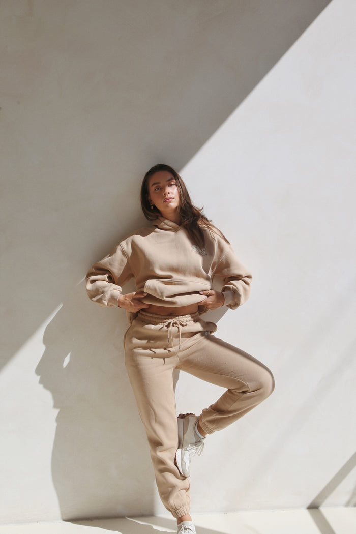 Woman standing in the latte hoodie and sweatpants set. Cosy Club 2.0 Adults Sweatpants in Latte by Skylaroseco