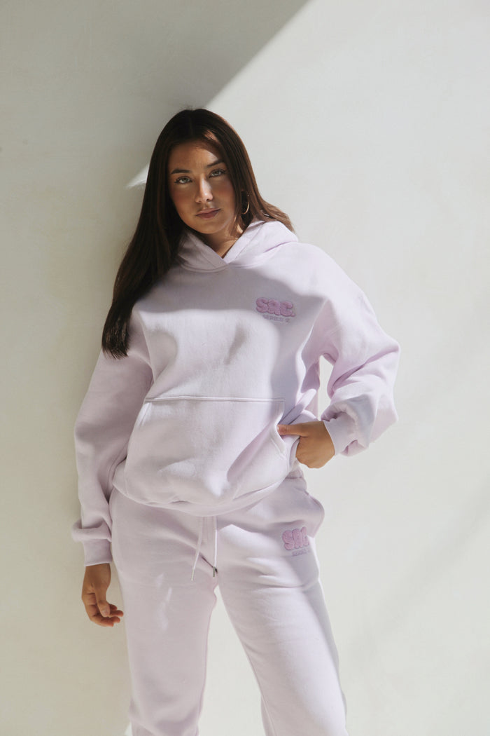 Woman wearing the lilac hoodie and sweatpants set, standing. Cosy Club 2.0 Adults Sweatpants in Lilac by Skylaroseco