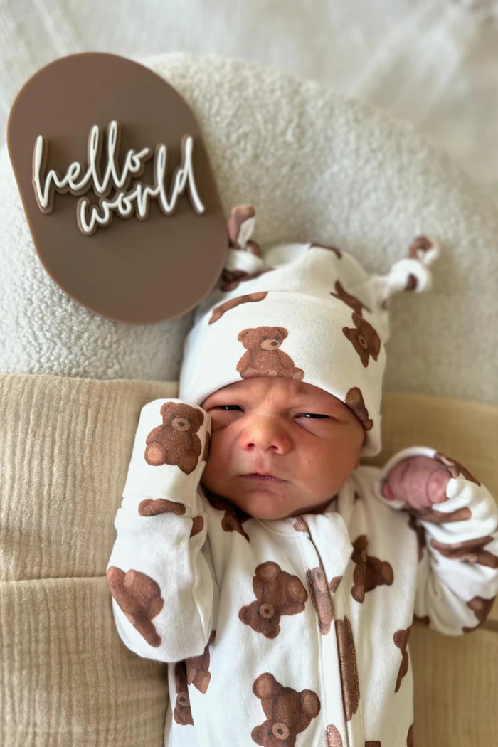 Newborn in the teddy-print beanie and matching onesie with a hello world plaque. Double Knot Beanie in Teddy by Skylaroseco