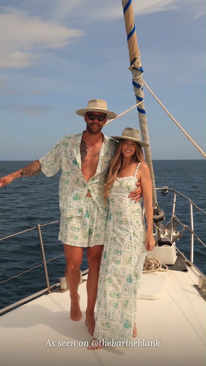 As seen on @thebarbieblank – couple wearing the Paradiso linen shirt, shorts and Maya maxi dress on a sailboat